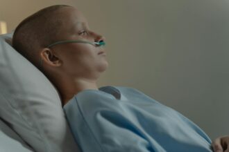 Researcher using precision equipment to slice tumor tissue samples for cancer analysis
