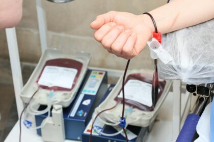 Paramedic administering Type O whole blood transfusion to trauma patient in ambulance