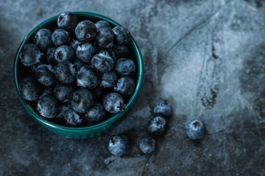 Bowl of fresh blueberries with scientific data overlay showing cardiovascular and metabolic benefits