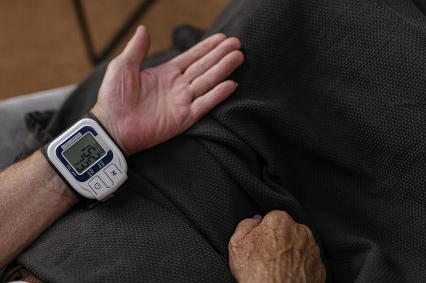 Digital blood pressure monitor with smartphone showing health data transmission
