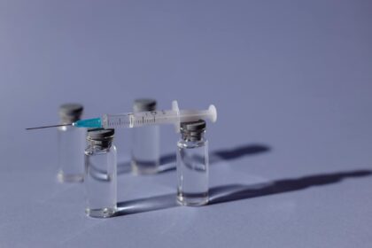 Medical researcher working with vaccine vials in laboratory setting for Lassa fever vaccine development
