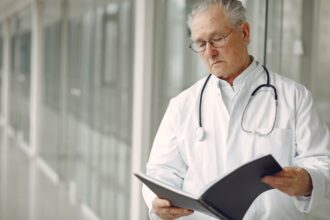 Elderly woman in medical scrubs representing oldest medical resident