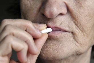 Elderly cancer patient taking oral medication at home instead of receiving IV treatment