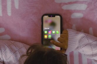 Parent distracted by phone while teenager sits nearby, illustrating parental screen time impact on adolescent attachment