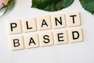 Colorful array of whole plant foods including vegetables, fruits, nuts and grains representing healthful plant-based diet