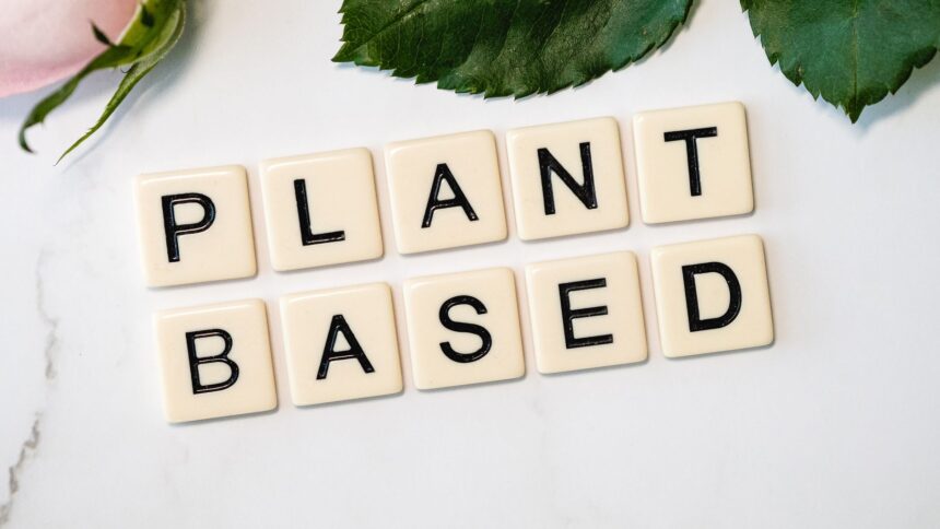 Colorful array of whole plant foods including vegetables, fruits, nuts and grains representing healthful plant-based diet