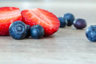 Bar chart showing polyphenol content across berries and plant foods, from chokeberry at 1,500+ mg to strawberry at 270 mg per 100g fresh weight