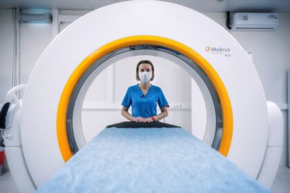 Child using miniature toy MRI scanner with stuffed animal during medical preparation session