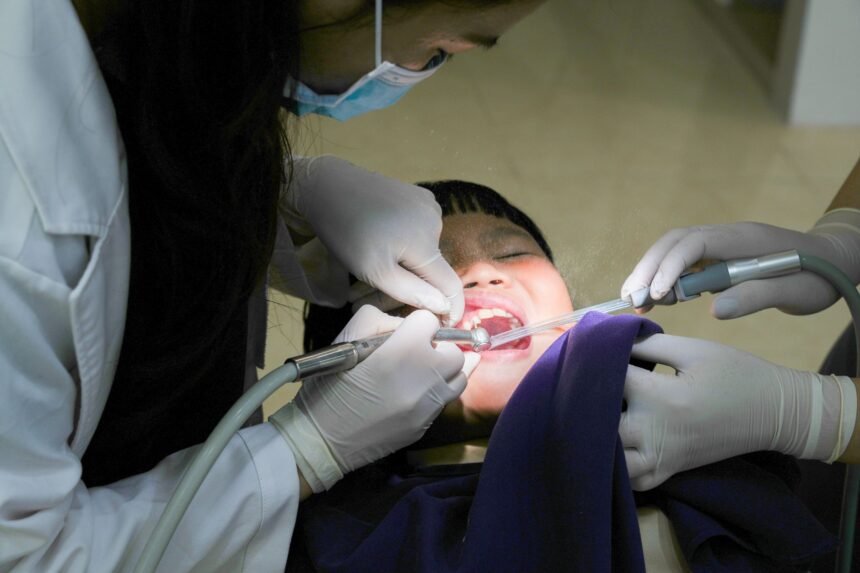 Young person at dentist office representing UK dental access crisis and student financial burden