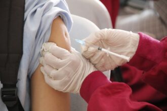 Medical professional preparing 4CMenB vaccine for gonorrhoea prevention programme