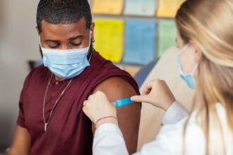 Healthcare professional reviewing vaccination guidelines and patient immunisation records