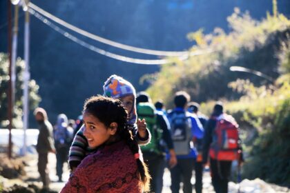 Children walking with belongings representing global migration challenges