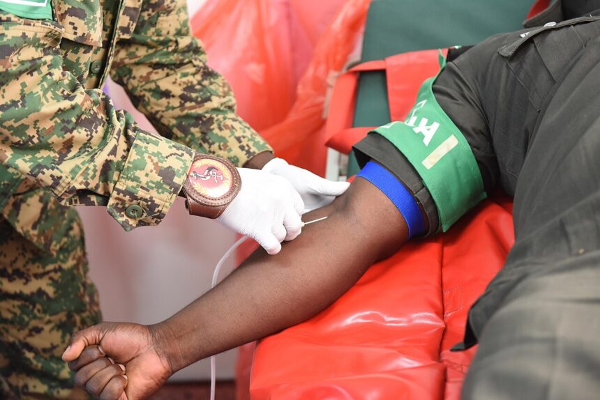 Medical professional holding blood donation bag with WHO Africa logo