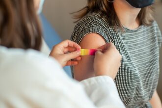 Infographic showing factors contributing to vaccine hesitancy: political distrust, disinformation, and service disruptions
