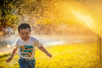 Child drinking water in summer heat; cooling strategies for paediatric heat illness prevention