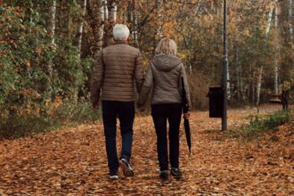Older adult walking outdoors in park, demonstrating daily physical activity for brain health