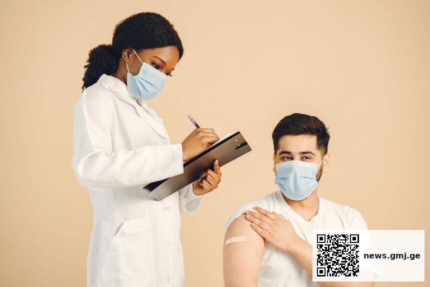 Medical researcher holding vaccine vial in laboratory setting