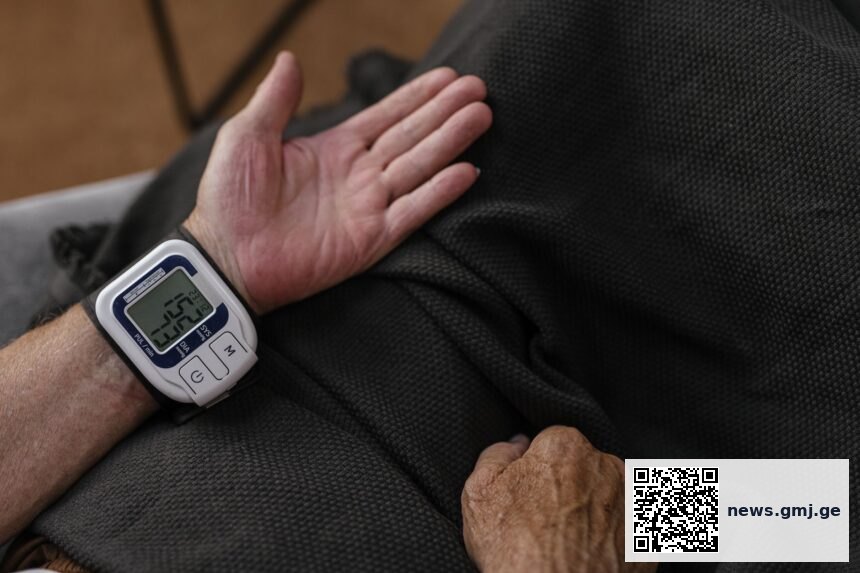 Digital blood pressure monitor with smartphone showing health data transmission